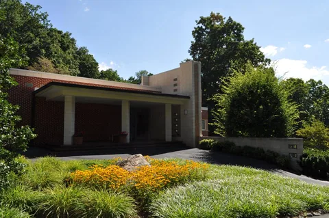 A Michael C. Brown residence: brick and concrete-block house with a deep entrance porch, set in a landscaped garden